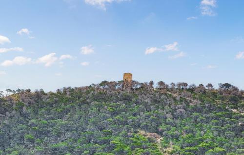 a tower on top of a hill with trees at Nice Apartment In Villajoyosa With Swimming Pool in Cala de Finestrat