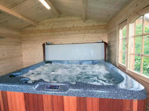 a jacuzzi tub in a wooden room at Bracken Log Cabin - S4468 in Glenfarg