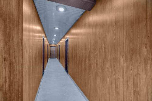 a hallway with wooden walls and a long aisle at FabHotel Vrishti Residency in Greater Noida