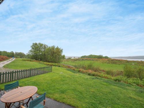 a table and chairs on a patio with a view of a field at Cruinn in Taynish