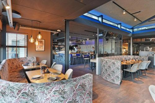 a restaurant with tables and chairs and a bar at Dock Hotel Stellendam in Stellendam