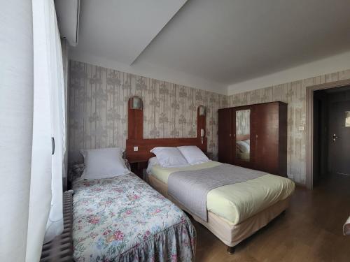a bedroom with two beds in a room at Touring Hotel in Bellegarde-sur-Valserine