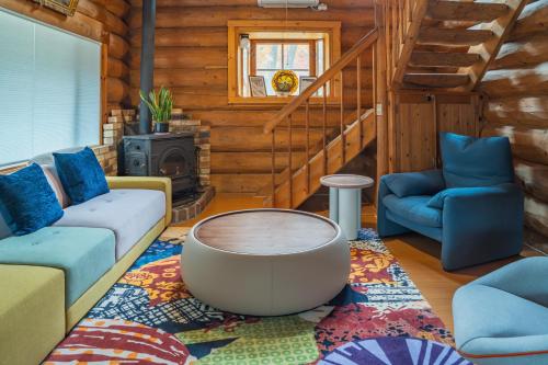a living room with a couch and a coffee table at Hakuba Riverside Loghouse in Hakuba