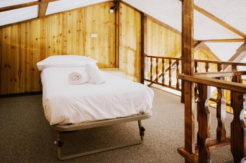 ein Bett in einem Zimmer neben einer Treppe in der Unterkunft Rifugio di Famiglia a due minuti dalle piste - Parcheggio e Wifi Gratuito in Sauze d'Oulx