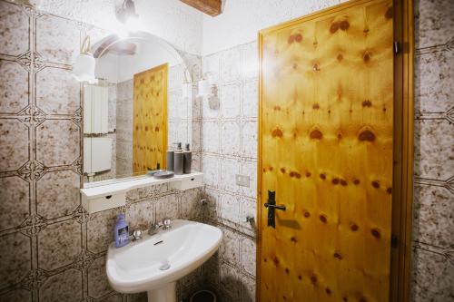 ein Badezimmer mit einem Waschbecken und einer gelben Tür in der Unterkunft Rifugio di Famiglia a due minuti dalle piste - Parcheggio e Wifi Gratuito in Sauze d'Oulx