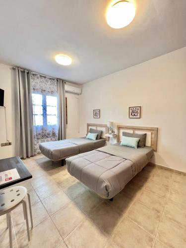 a bedroom with two beds and a table at Villa Petra in Tuineje