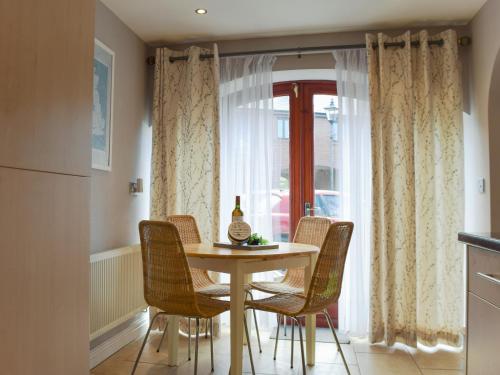 a table and chairs in a kitchen with a window at Lavender Cottage Was Fellside in Melmerby