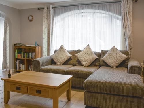 a living room with a couch and a coffee table at Lavender Cottage Was Fellside in Melmerby