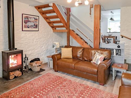 a living room with a couch and a wood stove at Appleloft in Crackington Haven