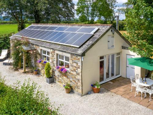 Blackberry Cottage في North Hill: منزل صغير على السطح مع لوحات شمسية