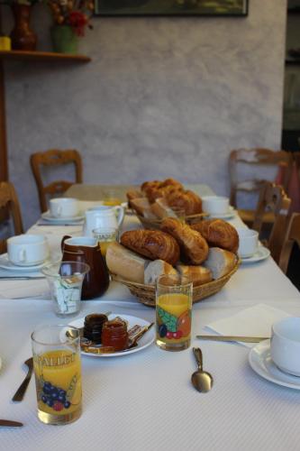 een tafel met brood en zoete deegwaren erop bij Touring Hotel in Bellegarde-sur-Valserine