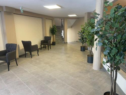 a waiting room with chairs and potted plants at Grand Cennet Beach Hotel in Akcay