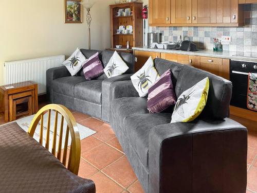 a living room with two couches and a kitchen at Bramble Cottage-19878 in Cloughton