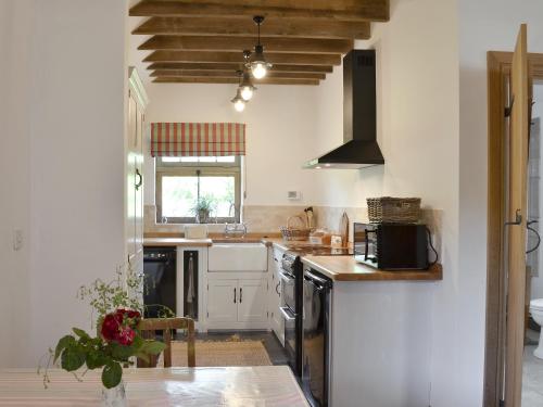 een keuken met witte kasten en zwarte apparaten bij Cowslip Cottage Ukc1898 in Dogdyke