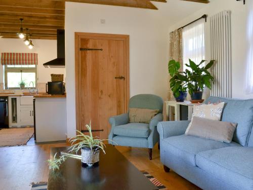 een woonkamer met een bank, stoelen en een tafel bij Cowslip Cottage Ukc1898 in Dogdyke