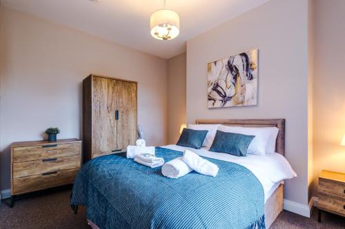een slaapkamer met een bed met handdoeken erop bij Charming family home in Heaton Norris