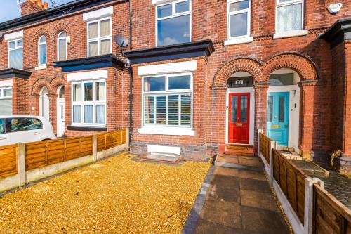 een rood bakstenen huis met een rode deur bij Charming family home in Heaton Norris