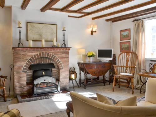 a living room with a brick fireplace and a desk at Toad Hall in Helmsley