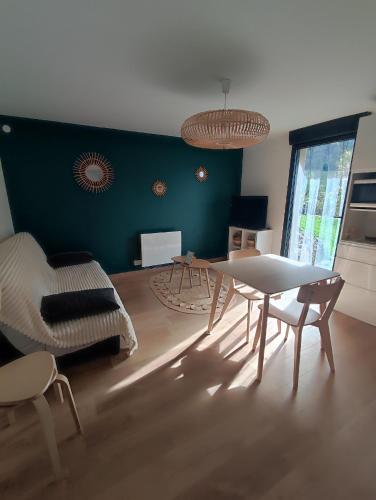 a living room with a table and a couch at Appartement à la campagne in Saint-Georges-de-Luzençon