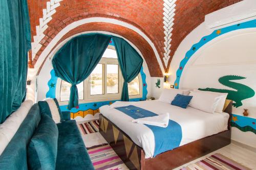 a bedroom with a bed and a couch at Casa Nile View rooms - Nubian House in Aswan