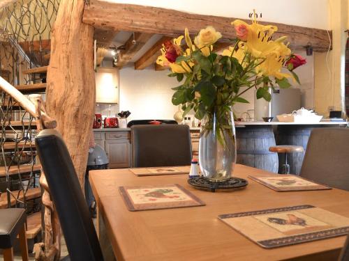 a wooden table with a vase of flowers on it at Meadow Barn in Ellingham