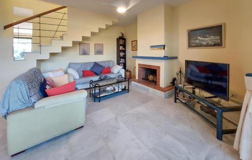ein Wohnzimmer mit Couch und Kamin in der Unterkunft 3 Bedroom Cozy Home In Islantilla - Isla Cris in Islantilla