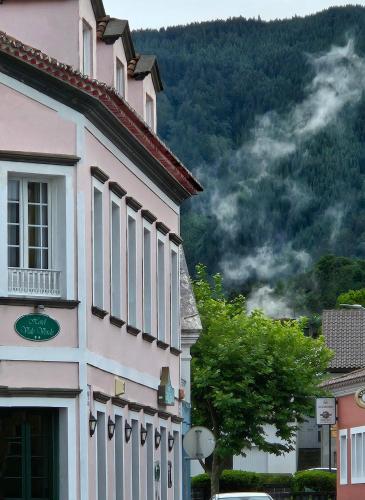 a building in a town with a mountain in the background at Hotel Vale Verde in Furnas