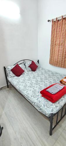 uma cama com almofadas vermelhas num quarto em The Duplex House HSR em Bangalore