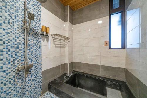 冬山郷にある浮雲拾光のバスタブと窓のあるバスルーム