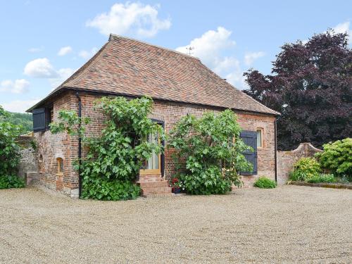 a brick house with two vines growing on it at Fig Cottage in Brabourne