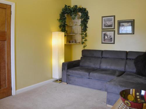 a living room with a couch and a lamp at High Moor Cottage in Dufton