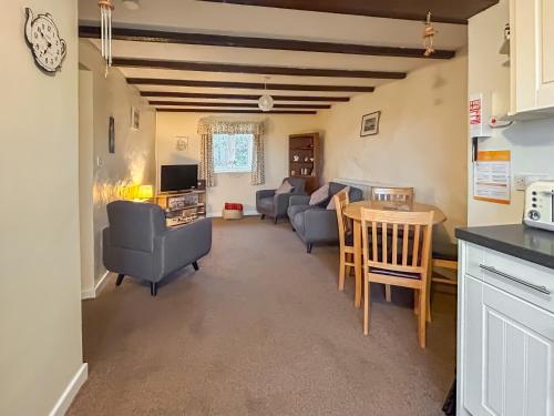 a living room with a couch and chairs and a table at Ty Main Cottage in Newborough