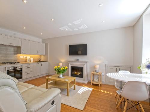 Una sala de estar con un sofá y una chimenea. en Lower Canterbury House, en Gattonside