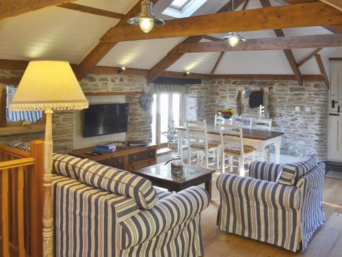 a living room with two couches and a table at The Stables By The Sea in Newquay