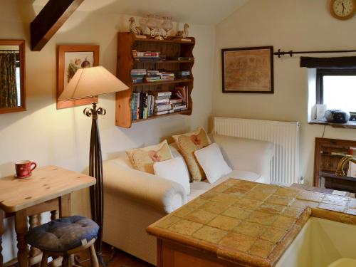 a living room with a couch and a table at Mushroom Cottage in Castleton