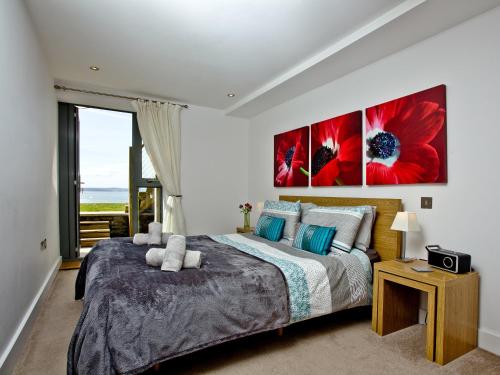 een slaapkamer met een groot bed met rode bloemen aan de muur bij 4 Ocean Point in Croyde