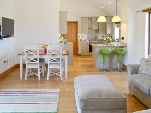 a living room and kitchen with a couch and a table at Swallows Retreat in Hartland
