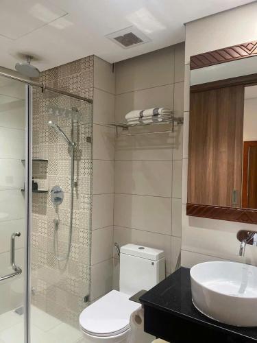 a bathroom with a shower and a toilet and a sink at Yang Apec Mandala Home in Phước Hậu (1)