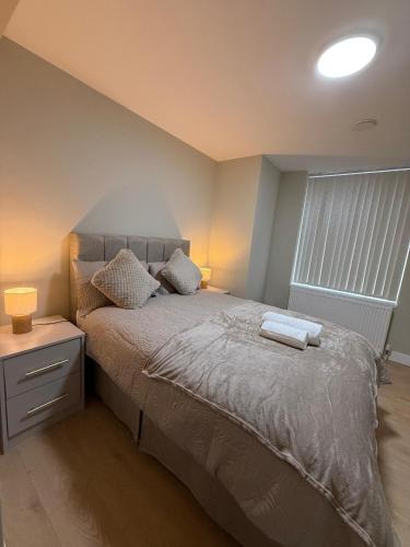 a bedroom with a bed with two towels on it at Britlodge Home in Manchester