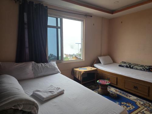 a small room with two beds and a window at Sunrise View Homestay in Tānsen