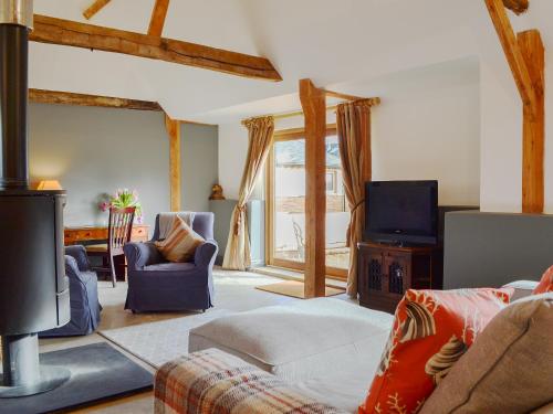 ein Wohnzimmer mit Sofa und Fernseher in der Unterkunft Chiddock Cottage - Ukc2540 in Fordingbridge