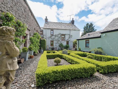a hedge garden in front of a house at The Mains in Keldhead
