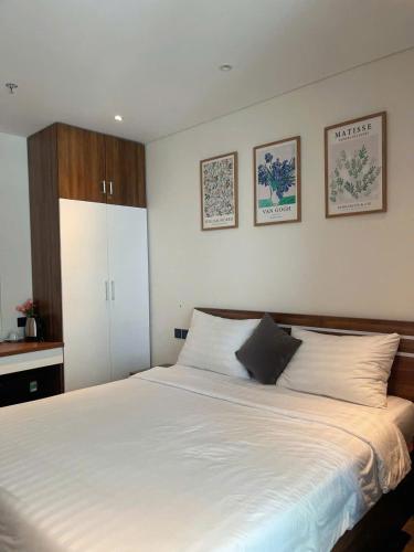a bedroom with a large white bed with two pillows at Yang Apec Mandala Home in Phước Hậu (1)
