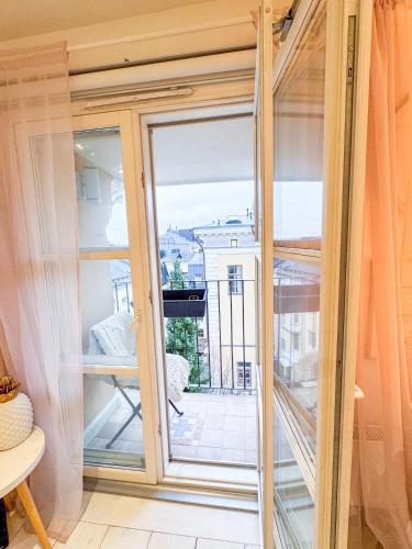 Una habitación con una gran puerta de cristal con balcón. en Skatta Secret Penthouse, en Helsinki