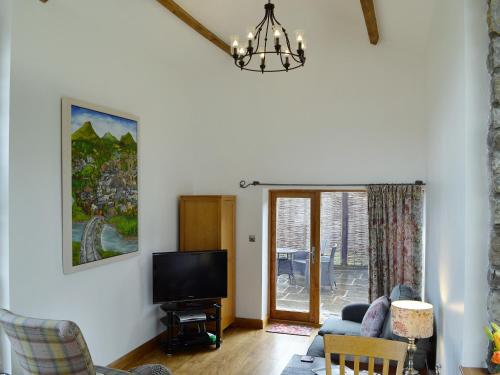 a living room with a couch and a tv at Little Barn in Gilwern