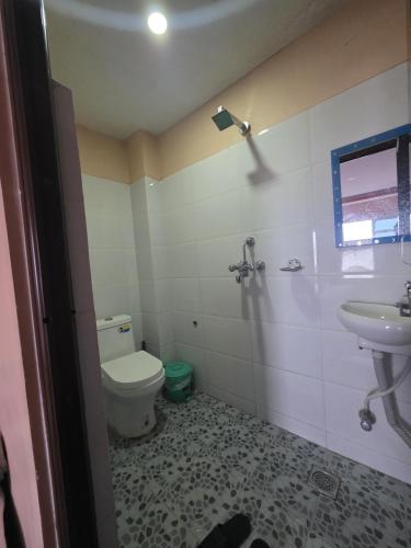 a bathroom with a toilet and a sink at Sunrise View Homestay in Tānsen