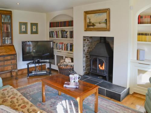 een woonkamer met open haard en tv bij The Linhay in Westleigh