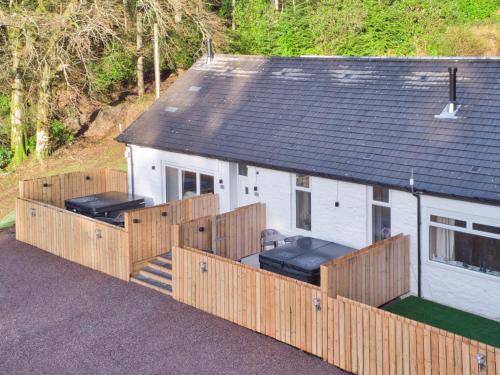 een wit huis met een houten hek eromheen bij Elfin Cottage - Uk7810 in Coirantee