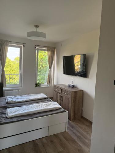 a bedroom with two beds and a flat screen tv at Modern Apartment in a Leafy Town Close to Prague 