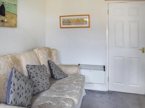 eine Couch mit Kissen darauf in einem Wohnzimmer in der Unterkunft Trevose Head - Uk47556 in Saint Merryn